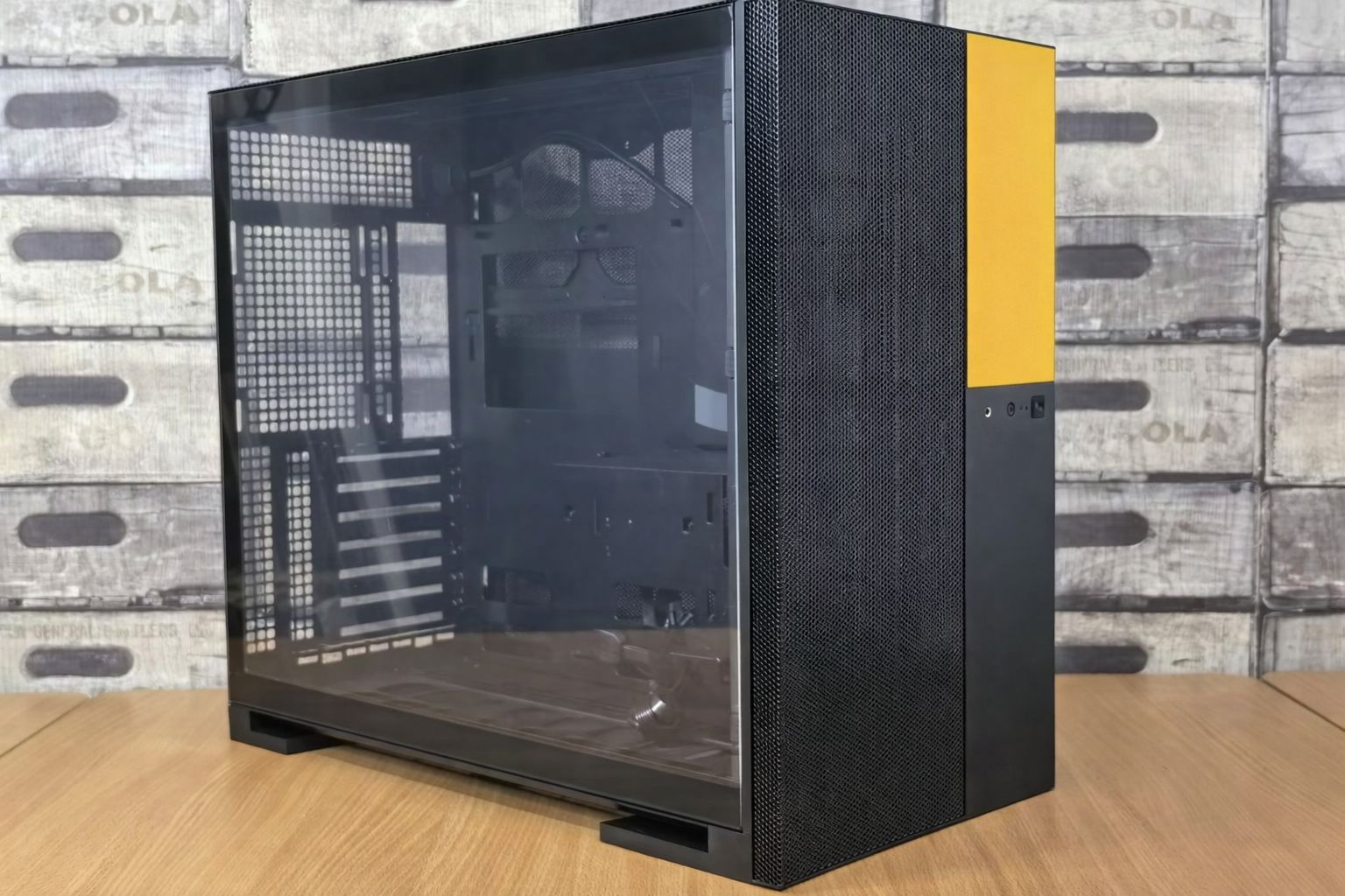 Ein schwarz-gelbes, schlankes Computergehäuse mit Glasseitenwand.