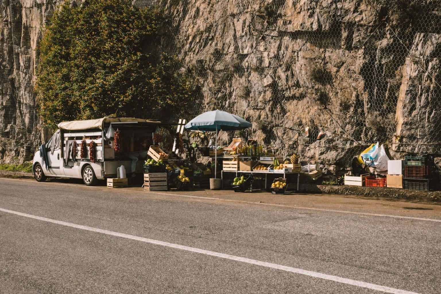 Fahrzeug mit Waren am Straßenrand, Felswand im Hintergrund